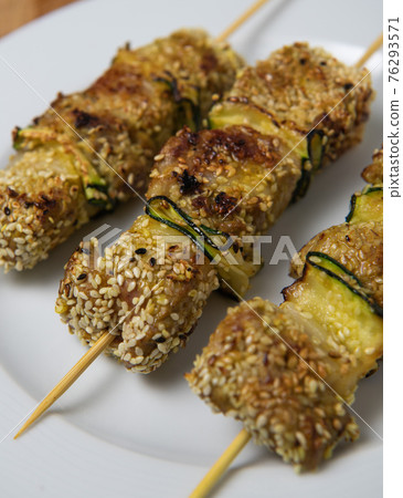 Lamb skewer with sesame seeds and slats of zucchini  76293571