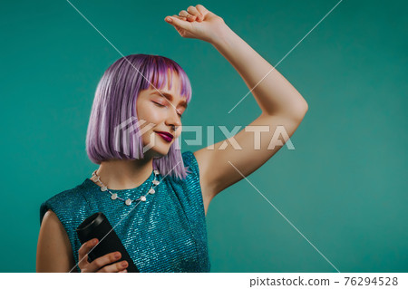 Unusual woman with dyed violet hairstyle listening to music by wireless portable speaker - modern Unusual woman with dyed violet hairstyle listening to music by wireless portable speaker - modern 76294528