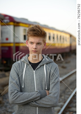 Young handsome teenage boy at the railway train station 76296792