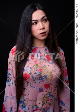 Young beautiful Asian transgender woman against black background 76296944