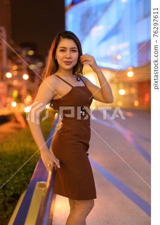 Beautiful Asian woman outdoors in Bangkok, Thailand at night 76297611