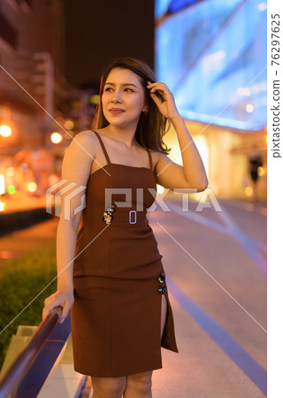 Beautiful Asian woman outdoors in Bangkok, Thailand at night 76297625