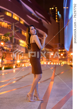 Full length shot of beautiful Asian woman outdoors in Bangkok, Thailand at night 76297792