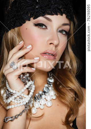 Perfect beauty and jewelry concept. Portrait of beautiful female model wearing ring, necklace and wristband on black background. Young blond woman shows glamorous finery Perfect beauty and jewelry concept. Portrait of beautiful female model wearing ring, necklace and wristband on black background. Young blond woman shows glamorous finery 76298095