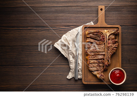 Sliced grilled T-bone beef steak from above and copy space Sliced grilled T-bone beef steak from above and copy space 76298139