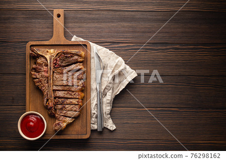 Sliced grilled T-bone beef steak from above and copy space Sliced grilled T-bone beef steak from above and copy space 76298162