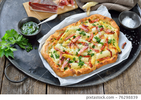 Tarte flambee from Alsace with fresh white asparagus and bacon 76298839