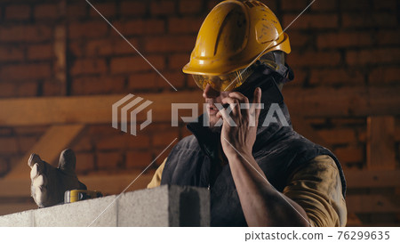 Man answering phone call on construction site 76299635