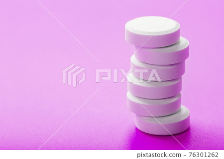White Ecstasy pills in a row on a pink background, isolate. White Ecstasy pills in a row on a pink background, isolate. 76301262