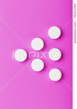 White Ecstasy pills in a row on a pink background, isolate. White Ecstasy pills in a row on a pink background, isolate. 76301264