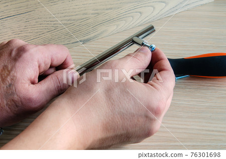 Assembling furniture, installing furniture decorative handles on the furniture facade Assembling furniture, installing furniture decorative handles on the furniture facade 76301698