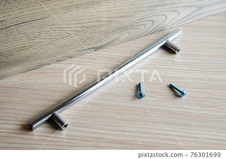 Assembling furniture, installing furniture decorative handles on the furniture facade Assembling furniture, installing furniture decorative handles on the furniture facade 76301699