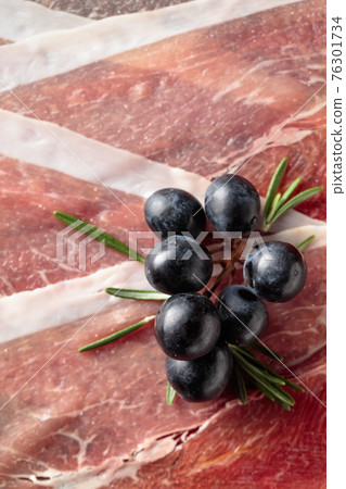 Prosciutto with grapes and rosemary. Prosciutto with grapes and rosemary. 76301734