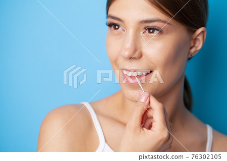 Woman uses brushes to clean the interdental spaces 76302105