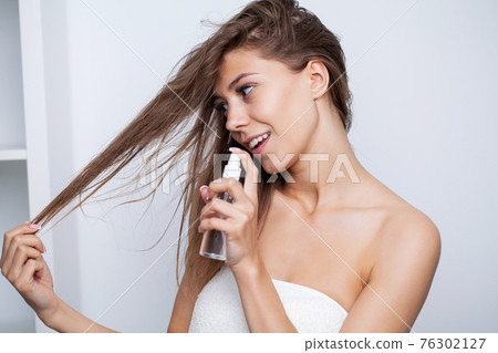 Woman with beautiful hair, applies vitamins for hair growth Woman with beautiful hair, applies vitamins for hair growth 76302127