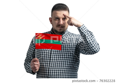 White guy holding a flag of Transnistria and a finger touches the temple on the head isolated on a white background White guy holding a flag of Transnistria and a finger touches the temple on the head isolated on a white background 76302228