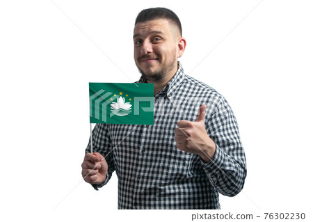White guy holding a flag of Macau and shows the class by hand isolated on a white background. Like for Macau White guy holding a flag of Macau and shows the class by hand isolated on a white background. Like for Macau 76302230