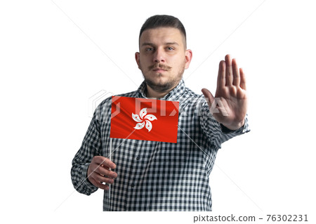 White guy holding a flag of Hong Kong and with a serious face shows a hand stop sign isolated on a white background White guy holding a flag of Hong Kong and with a serious face shows a hand stop sign isolated on a white background 76302231