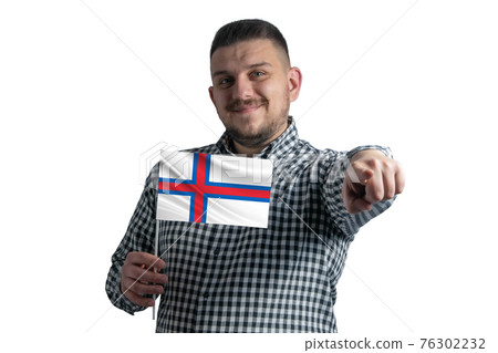 White guy holding a flag of Faroe Islands and points forward in front of him isolated on a white background White guy holding a flag of Faroe Islands and points forward in front of him isolated on a white background 76302232