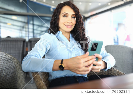 Luxury woman sitting in a chair in a restaurant Luxury woman sitting in a chair in a restaurant 76302524