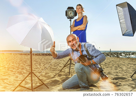 Photographer with female model on sea coast 76302657