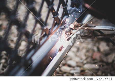 Welder welds the steel toothed rack to gate before setting up automated gate operator 76303644