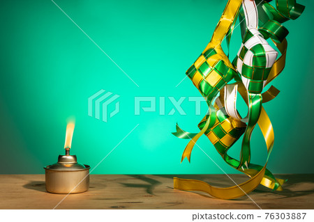 Conceptual traditional Malay oil lamp named pelita with decorative ketupat for Hari Raya Aidilfitri celebration Conceptual traditional Malay oil lamp named pelita with decorative ketupat for Hari Raya Aidilfitri celebration 76303887