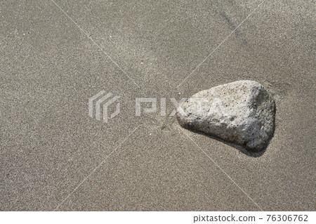 在海灘的沙子埋沒的小卵石 76306762