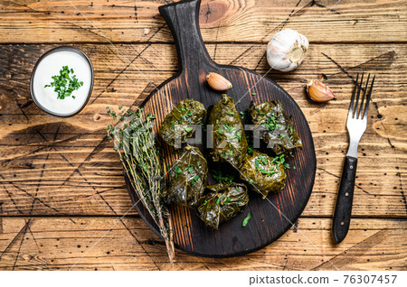 Traditional georgian dolma in grape leaves. wooden background. Top view 76307457