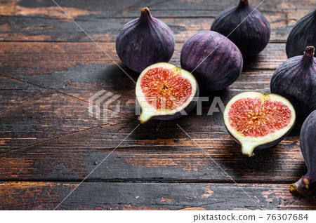 Purple figs on a wooden table. Dark wooden background. Top view. Copy space Purple figs on a wooden table. Dark wooden background. Top view. Copy space 76307684
