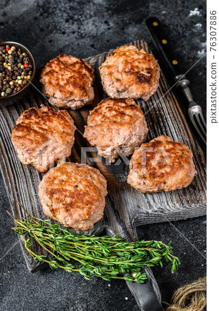 Roasted cutlets from beef and pork meat. Black background. Top view Roasted cutlets from beef and pork meat. Black background. Top view 76307886