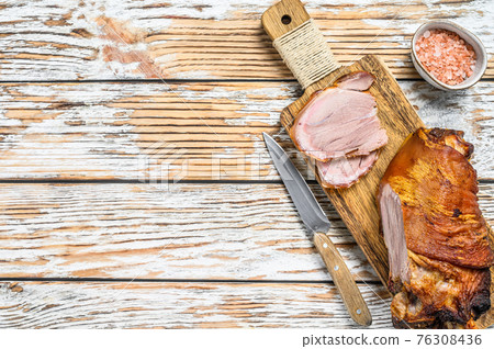 Sliced roasted pork knuckle on a cutting board. wooden background. Top view. Copy space 76308436