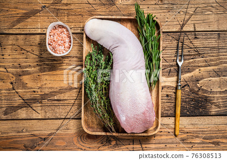 Raw pork tongue on butcher tray with meat knife. wooden background. Top view 76308513