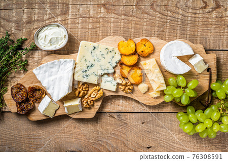 Assorted Cheese Brie, Camembert, Roquefort, parmesan, blue cream cheese with grape, fig, bread and nuts. wooden background. Top view 76308591