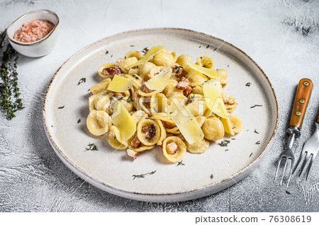 Orecchiette homemade carbonara pasta with pancetta, egg, hard parmesan cheese and cream sauce. White background. Top view 76308619