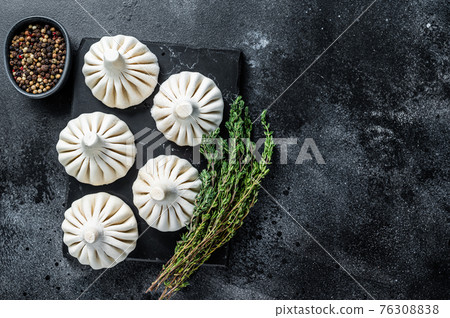 Raw dumplings Khinkali with beef and lamb meat. Black background. Top view. Copy space Raw dumplings Khinkali with beef and lamb meat. Black background. Top view. Copy space 76308838