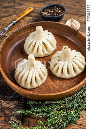 Boiled Khinkali Dumplings with mutton lamb meat in wooden plate. wooden background. Top view 76308881
