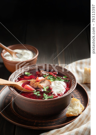 Freshly cooked borscht - traditional dish of Russian and Ukrainian cuisine in earthenware dish with bacon, sour cream and garlic, vertical image Freshly cooked borscht - traditional dish of Russian and Ukrainian cuisine in earthenware dish with bacon, sour cream and garlic, vertical image 76313397