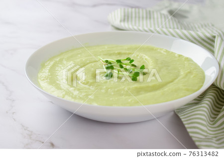 Classic french chilled cream soup vichyssoise - warm or cold potato leek soup topped with microgreens on marble table background. Healthy food concept. Selective focus 76313482