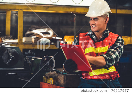 Manufacturing worker working with clipboard to do job procedure checklist . Manufacturing worker working with clipboard to do job procedure checklist . 76317977
