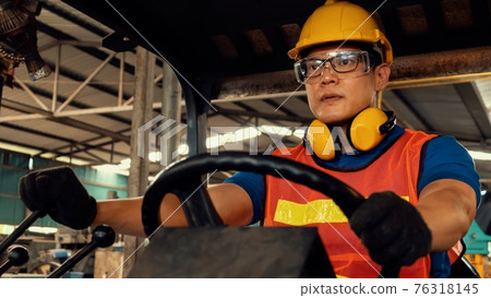 Skillful worker drives forklift in the factory . Skillful worker drives forklift in the factory . 76318145