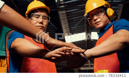Team of skillful factory workers showing unity partnership and support 76318411
