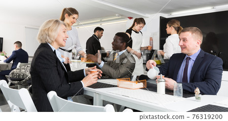 employees talking and drinking hot drinks employees talking and drinking hot drinks 76319200