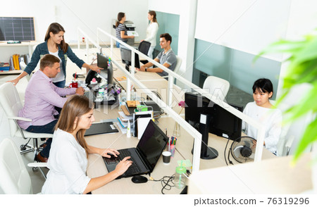 People working with computers and laptops in modern office 76319296