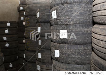 Storage dirty car tires. Pile of old used rubber tires. Warehouse. Storage dirty car tires. Pile of old used rubber tires. Warehouse. 76320573
