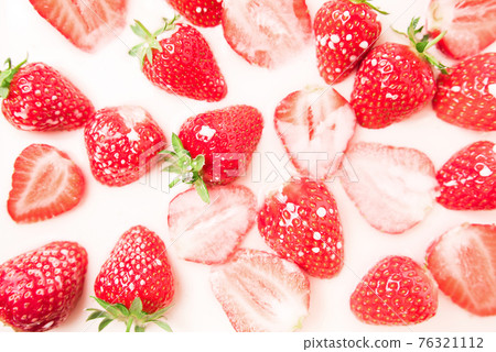 A lot of ripe juicy strawberries in milk, cream or yogurt. 76321112