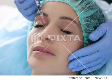 Beautician gives woman rejuvenating injection into skin of face Beautician gives woman rejuvenating injection into skin of face 76321619