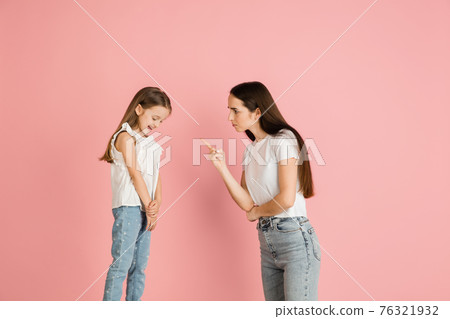 Young woman and girl, mother and daughter isolated over pink background. 76321932