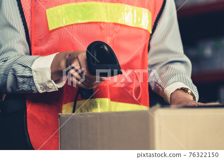 Warehouse worker using barcode scanner in storehouse Warehouse worker using barcode scanner in storehouse 76322150