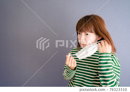Young woman worries about rough skin due to mask 76323310